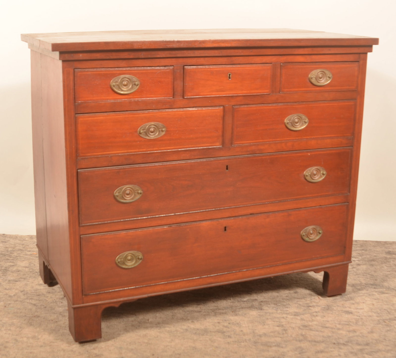 Mahogany Neoclassical Chest of Drawers: Three over two over two drawers, early-19th-century chest with inlay and original brasses. 37"H x 42 1/2"W x 23 3/4"D
