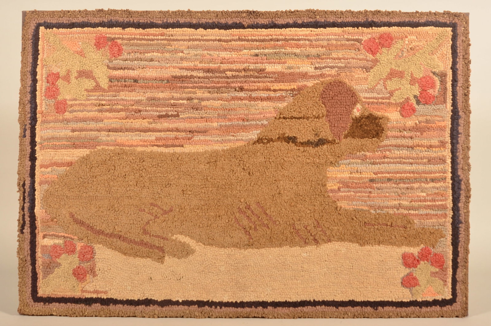 Antique Hooked Rug Depicting A Resting Dog: Mounted hooked rug depicting a dog with floral embellishments. 27"H x 40"W