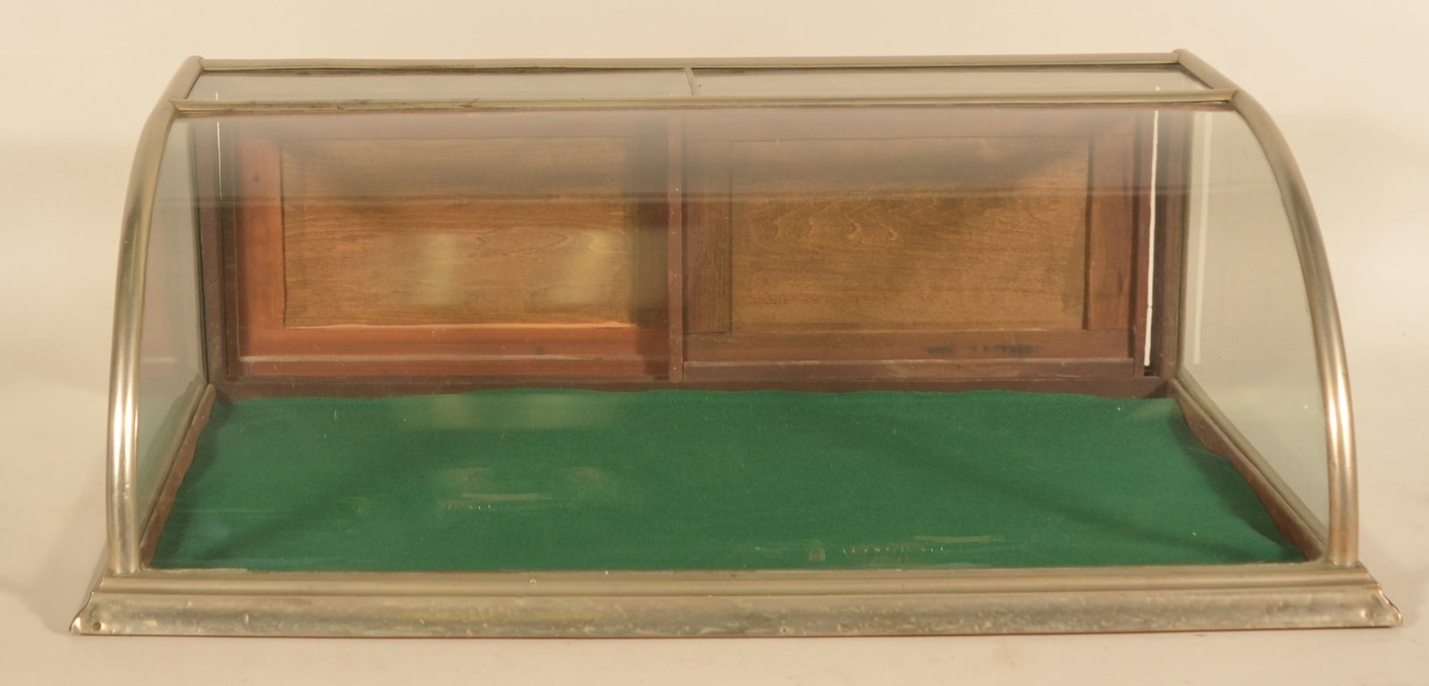 Small Curved Front Nickel-Plated Showcase: Nice smaller size, late-19th century showcase with original glass and two sliding rear doors. Base is stenciled twice "Philadelphia Show Case Works 111 N 4th St. Phila PA". Provenance: The collection