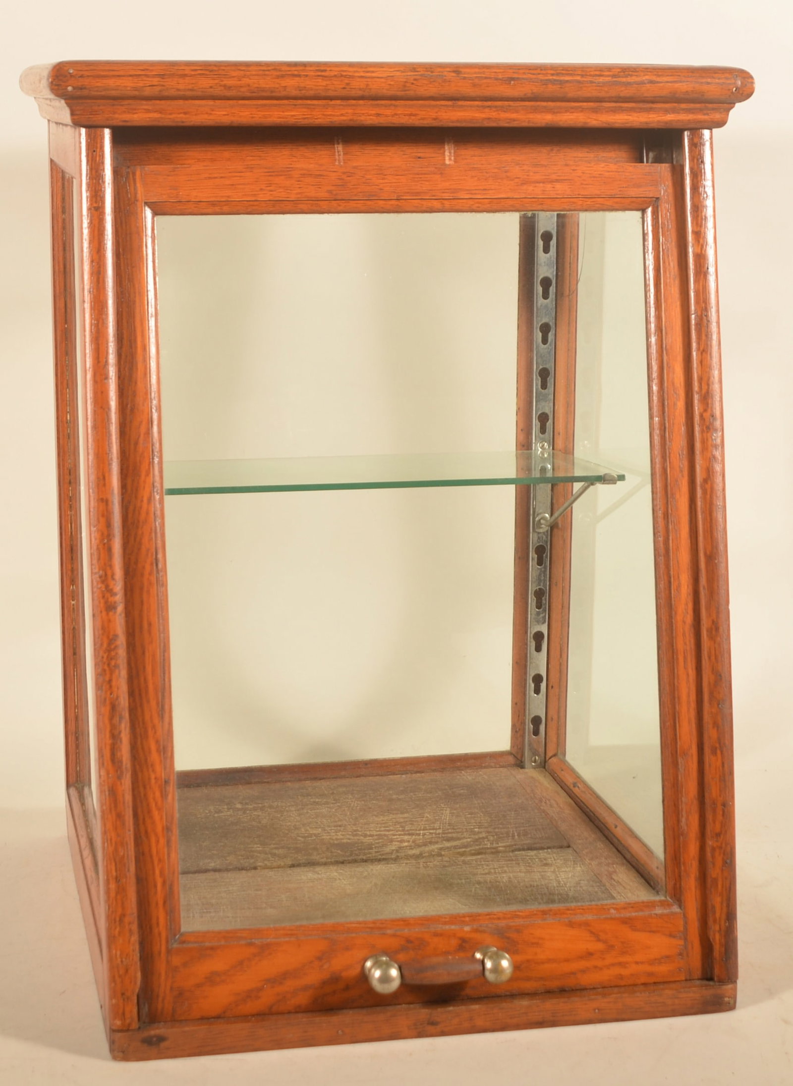 Unusual Oak & Glass Slide-Front Display Case: Very nice, canted country store display case, ca. 1900. Nickel-plated and turned oak handle is used to raise the front panel. An air pocket at the top between the crown molding and the top board allow