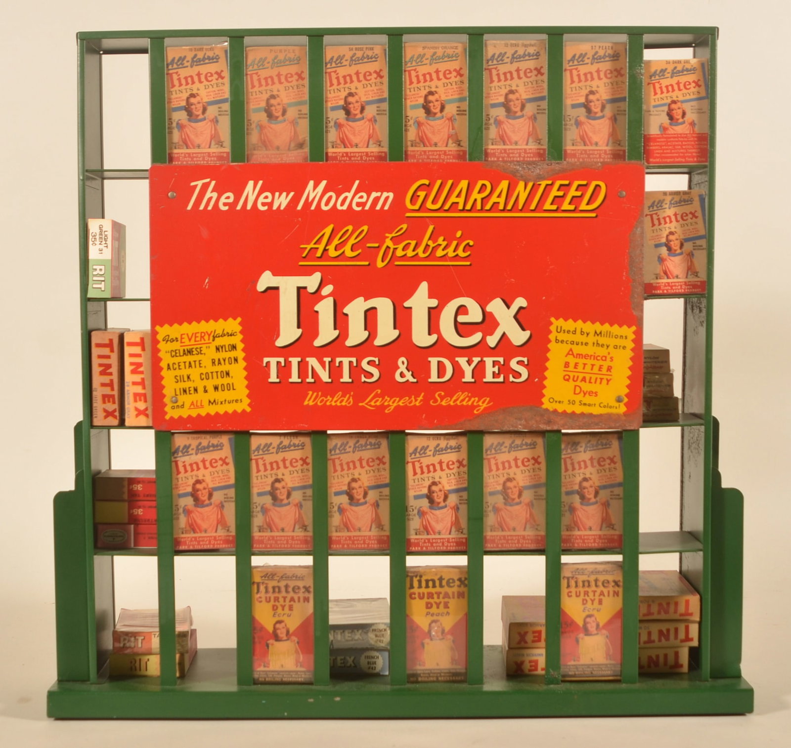 Vintage Tintex Dyes Counter Display: Metal display with sign advertising Tintex tints and dyes. Display comes with a number of boxes of Tintex and some from their competitor. Brochure holders on each side. Provenance: The collection of