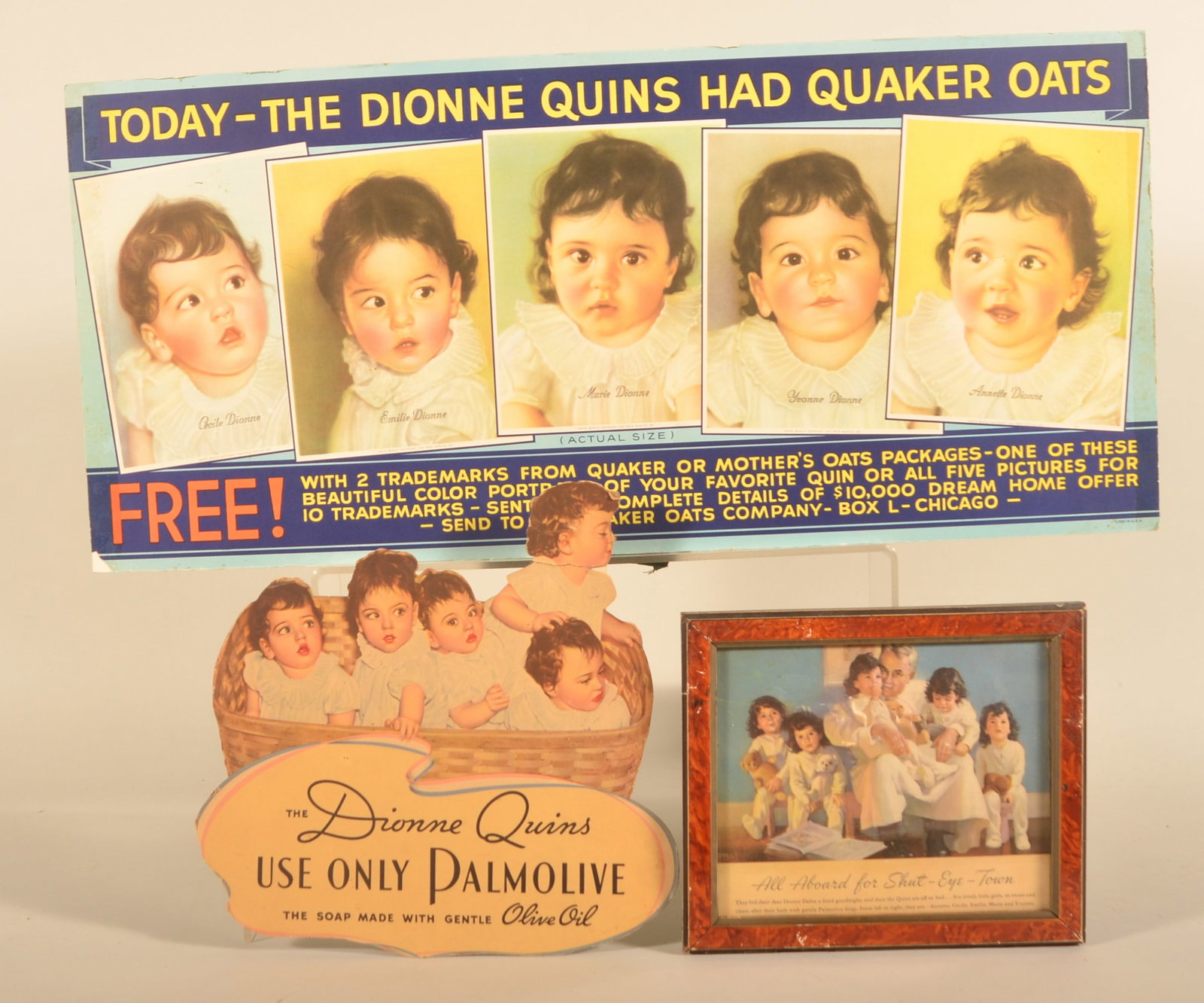 1930s Dionne Quintuplets Advertising Signs: Group of three items. A horizontal mounted paper advertising sign for Quaker Oats, featuring (in actual size!) the five babies. A smaller figural cardboard ad for Palmolive Soap and a framed paper ad 