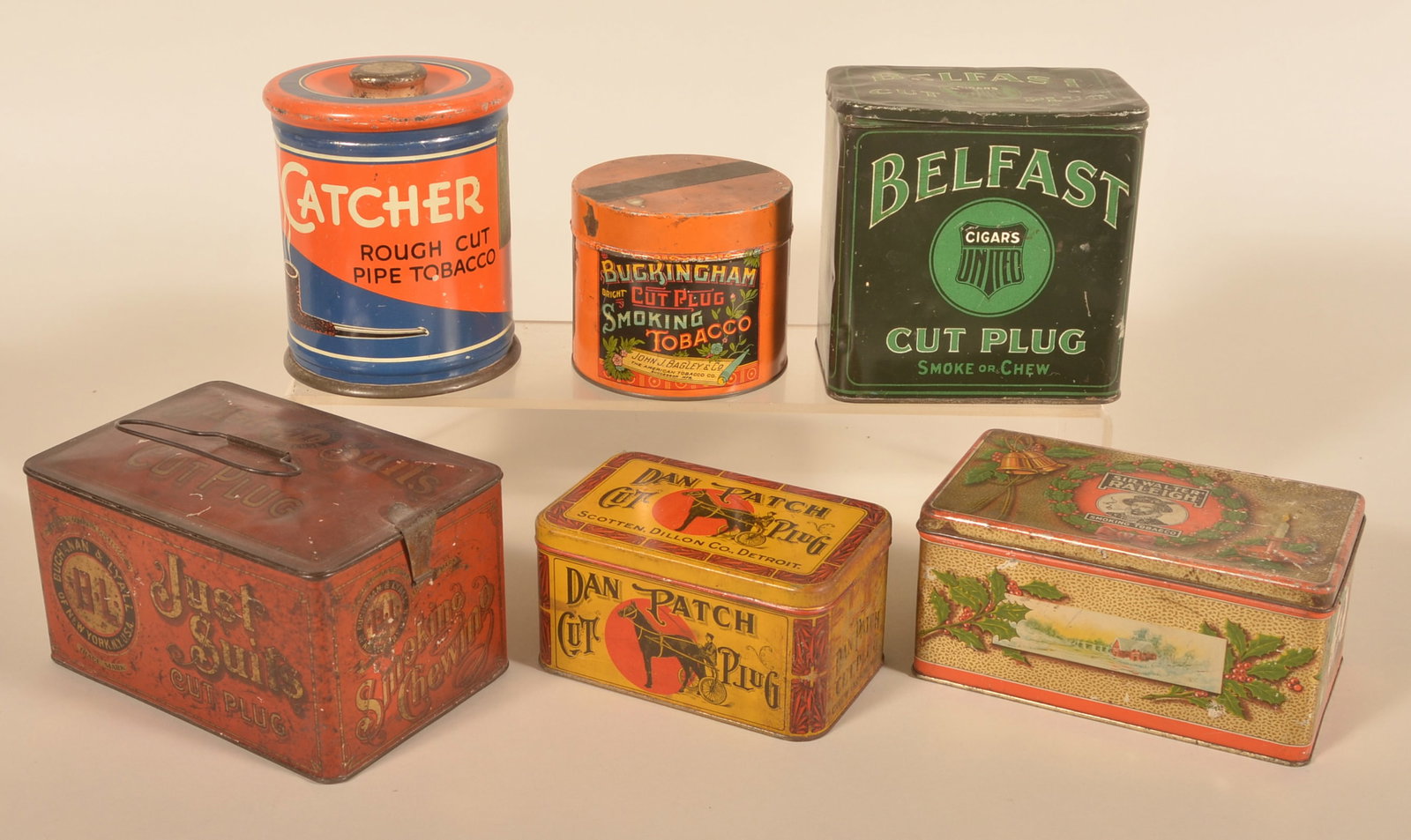 Six Tobacco Tins Incl Dan Patch, Catcher & Belfast: Six tobacco tins including a Just Suits lunchbox, Dan Patch, Christmas release of Sir Walter Raleigh, round Catcher and a small slip-top Buckingham in orange. Catcher tin, 6"H x 5"D