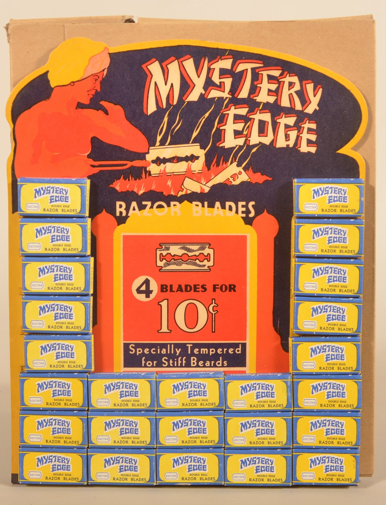 "Mystery Edge" NOS Easel-Back Razor Blade Display: Lithograph features a genie at work with his cauldron making razor blades. With the original protective cardboard shipping holder. Ca. 1930s. 13"H x 10 1/2"W