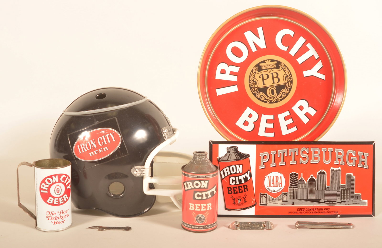 Collection of Iron City Beer Ephemera: Nice collection of various items includes a vintage serving tray, a beer can with an added "Handy" handle, cone top reissue can from their Latrobe operations, metal-over-cardboard sign from the 2020 B