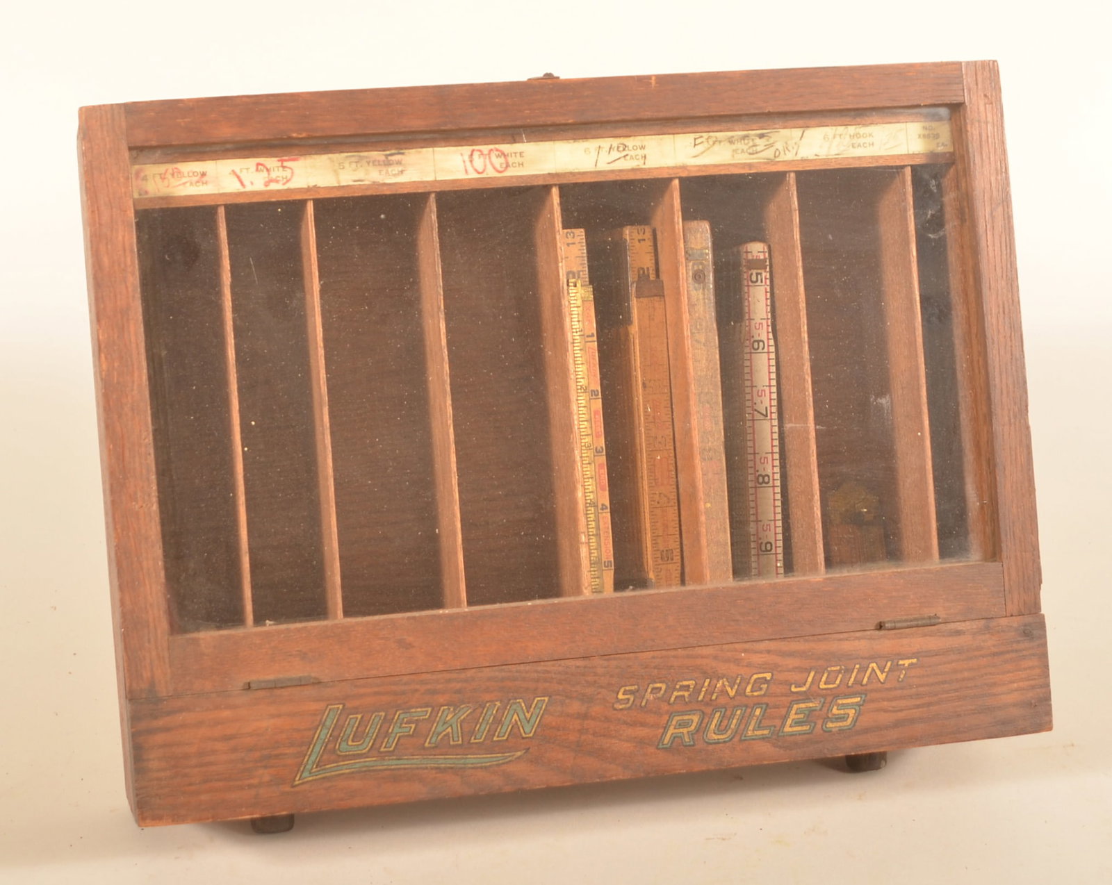 Great Oak & Glass Lufkin Ruler Display Cabinet: Great original finish and labels. Glass front showing slots for different size rulers. The original label is across the top with later pricing added. Provenance: The collection of Russell and Darlene 