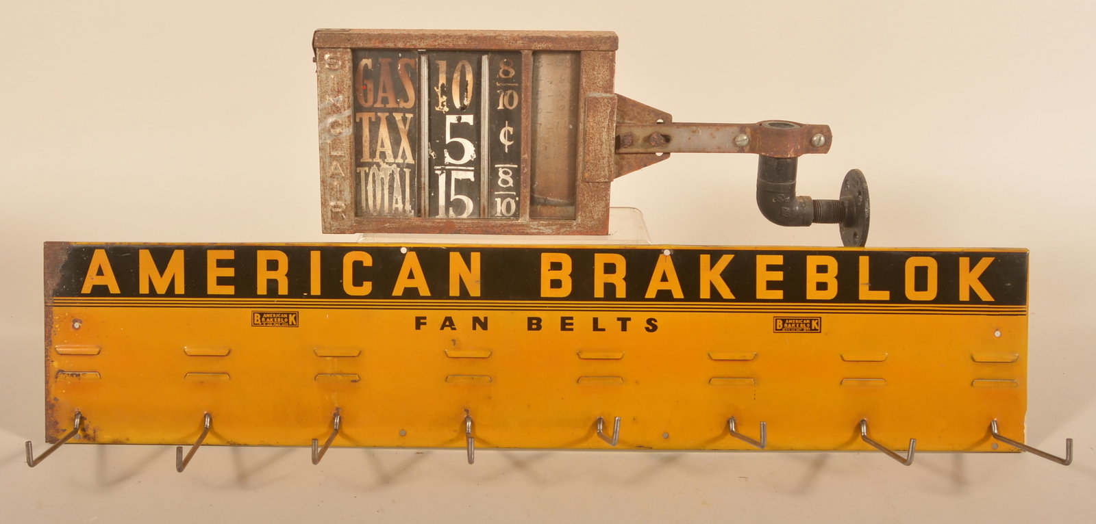 American Fan Belts Display & Sinclair Gas Pricer: Painted American Brake Block metal hanging display with eight hanging hooks. A double-sided Sinclair Gas pricer from a visible pump with the original paper pricing. Provenance: The collection of Russe