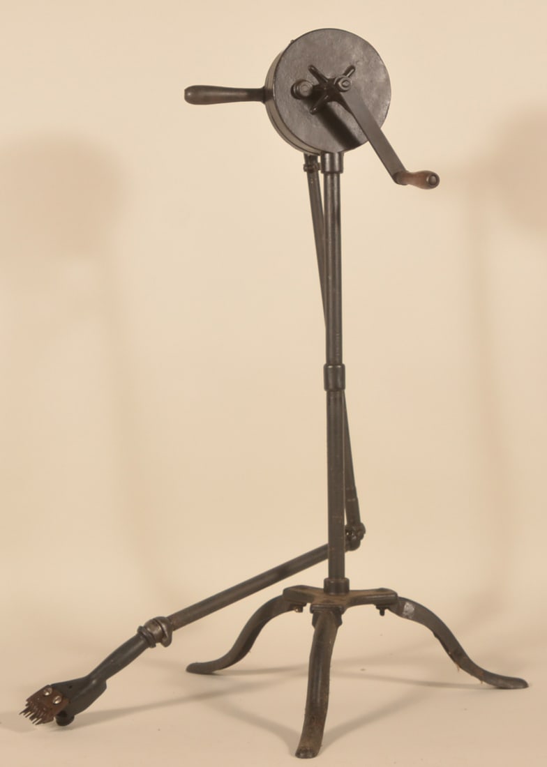 Chicago Flexible Cast Iron Sheep Shearing Machine: Cast iron machine on tripod. Metal plaque attached to crank case with maker name. Articulated iron hose with shearing attachment. Early-20th century. Provenance: The collection of Russell and Darlene 
