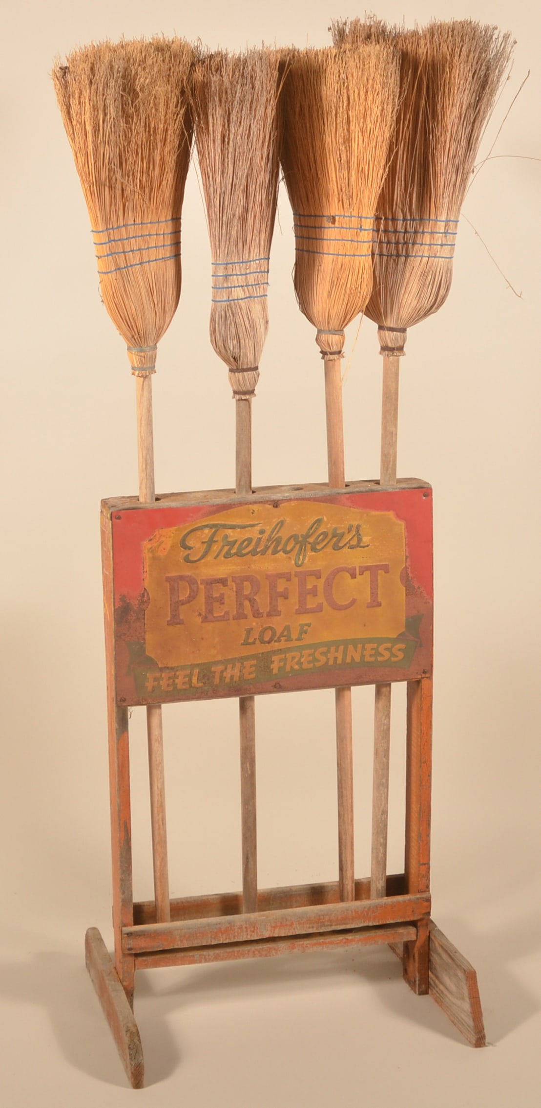 Freihofer's Bread Country Store Broom Display: Great primitive look. Original, painted wood frame with embossed tin sign. With four vintage weathered brooms. Provenance: The collection of Russell and Darlene Snyder. 34 1/2"H x 18"W x 22"D (without