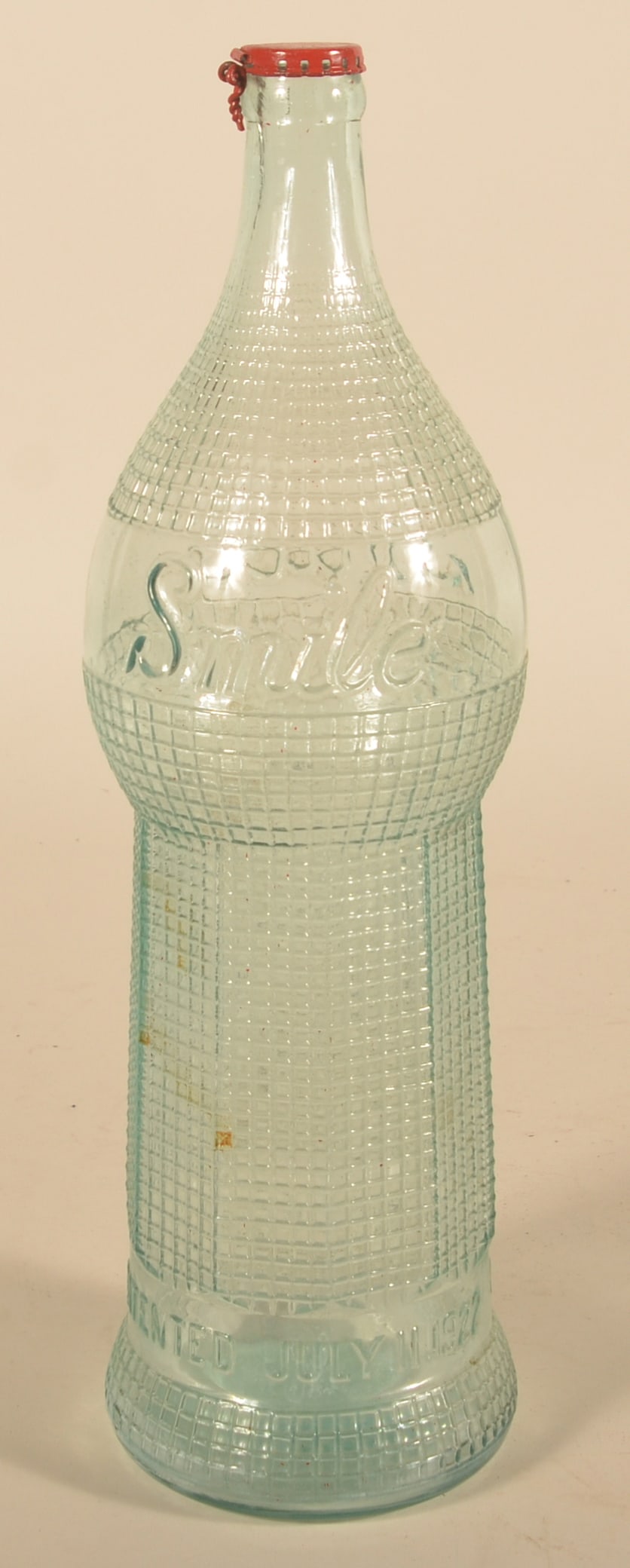 Large Glass "Smile" Soda Display Bottle: Embossed bottle with July 11, 1922 patent date. Original metal lid painted red. 18 1/2"H