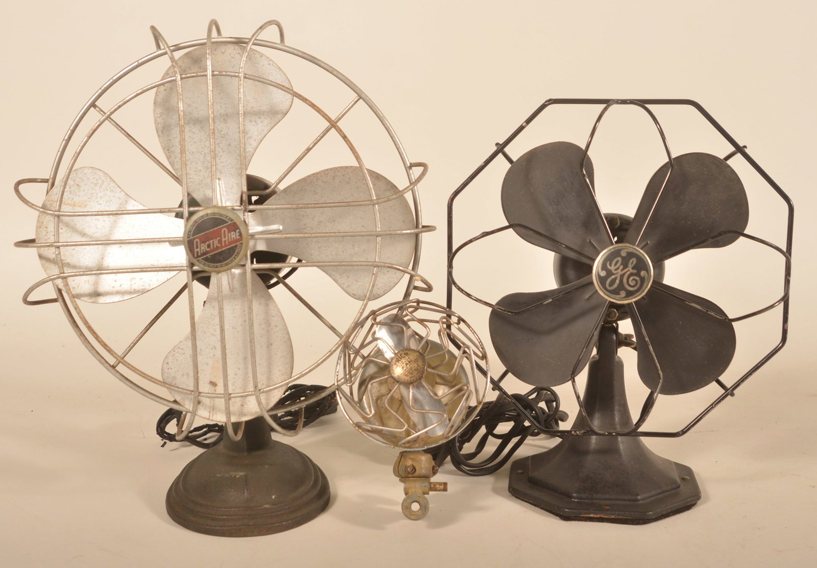 Three Vintage Wire & Steel Fans: G/E, small Trico and an Arctic Aire with a nice Art Deco base. Provenance: The collection of Linda and the late Ed Althouse. Trico, 5"H