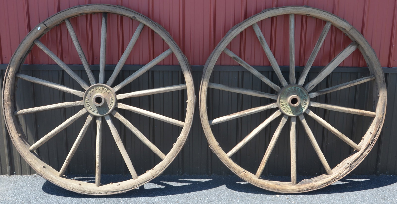 Pair of Massey Harris Wood Spoke Tractor Wheels: Massive wood spoke wheels with steel rims and cast iron hubs marked with maker's mark. 55" diam.