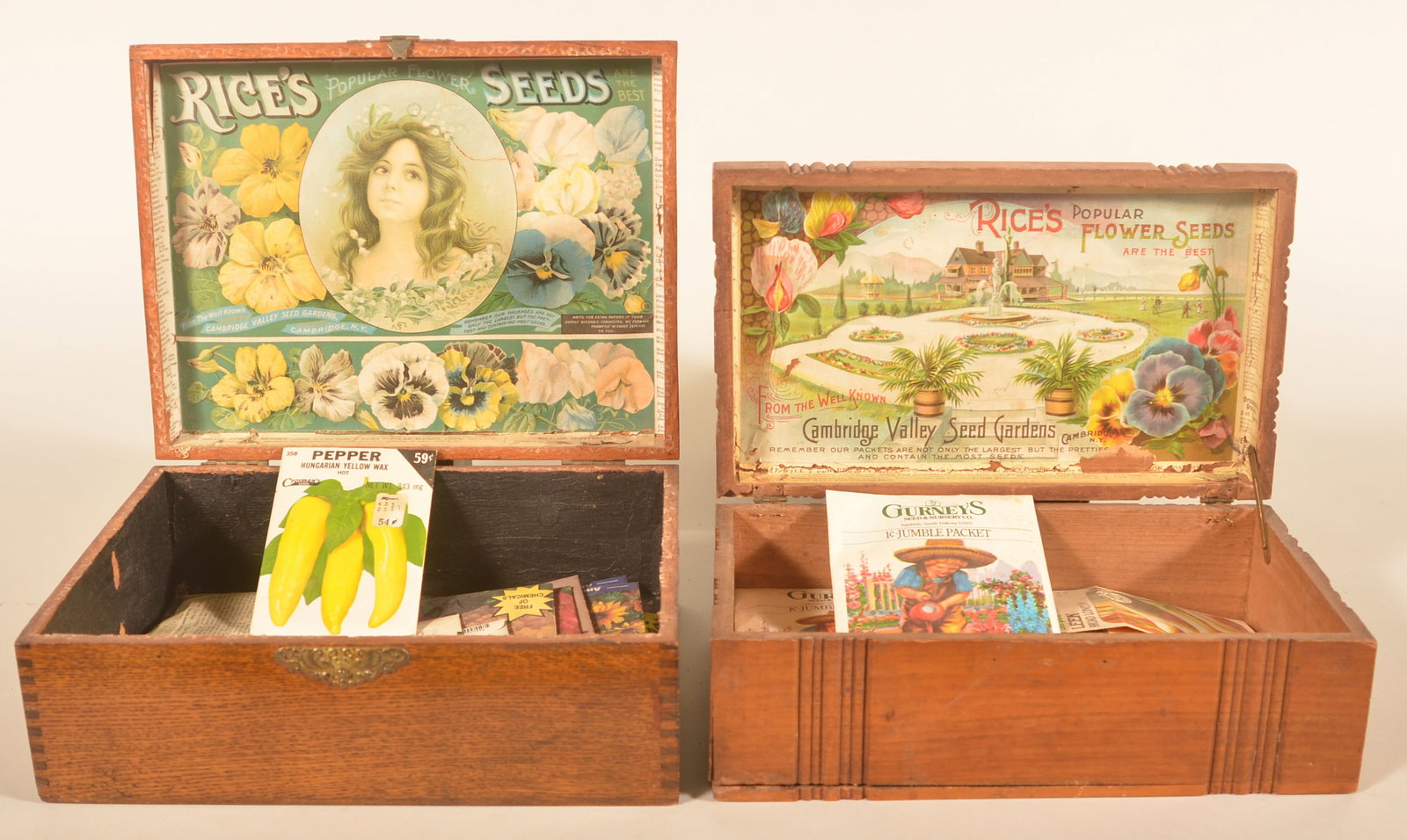 Two Rice's Seed Display Boxes: Two different style display boxes with paper labels on interior of lids. The label with the mansion and lush grounds is a more difficult label to find. Each box with vintage seed packs. Provenance: Th