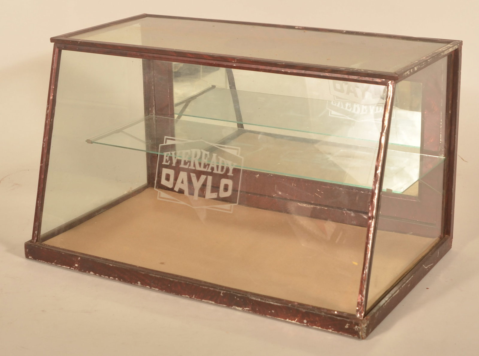 Early Eveready Daylo Tin & Glass Counter Display: Etched glass cabinet with glass shelf. Faux grain-painted metal body. Pull down door in back. 1920s. Provenance: The collection of Russell and Darlene Snyder. 12 1/4"H x 20 1/2"W x 12 1/4"D