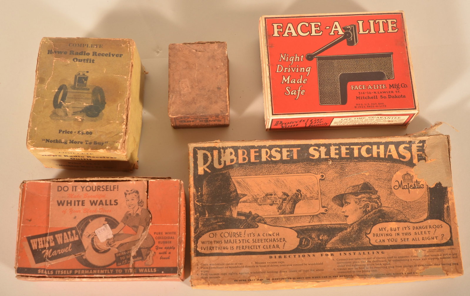 Group Vintage After-Market Automobile Accessories: Group includes box with bottles of do-it-yourself white walls, Howe radio receiver outfit, Face-A-Lite glare shield, box of tire bolts and Rubberset Sleetchase. Provenance: The collection of Russell a