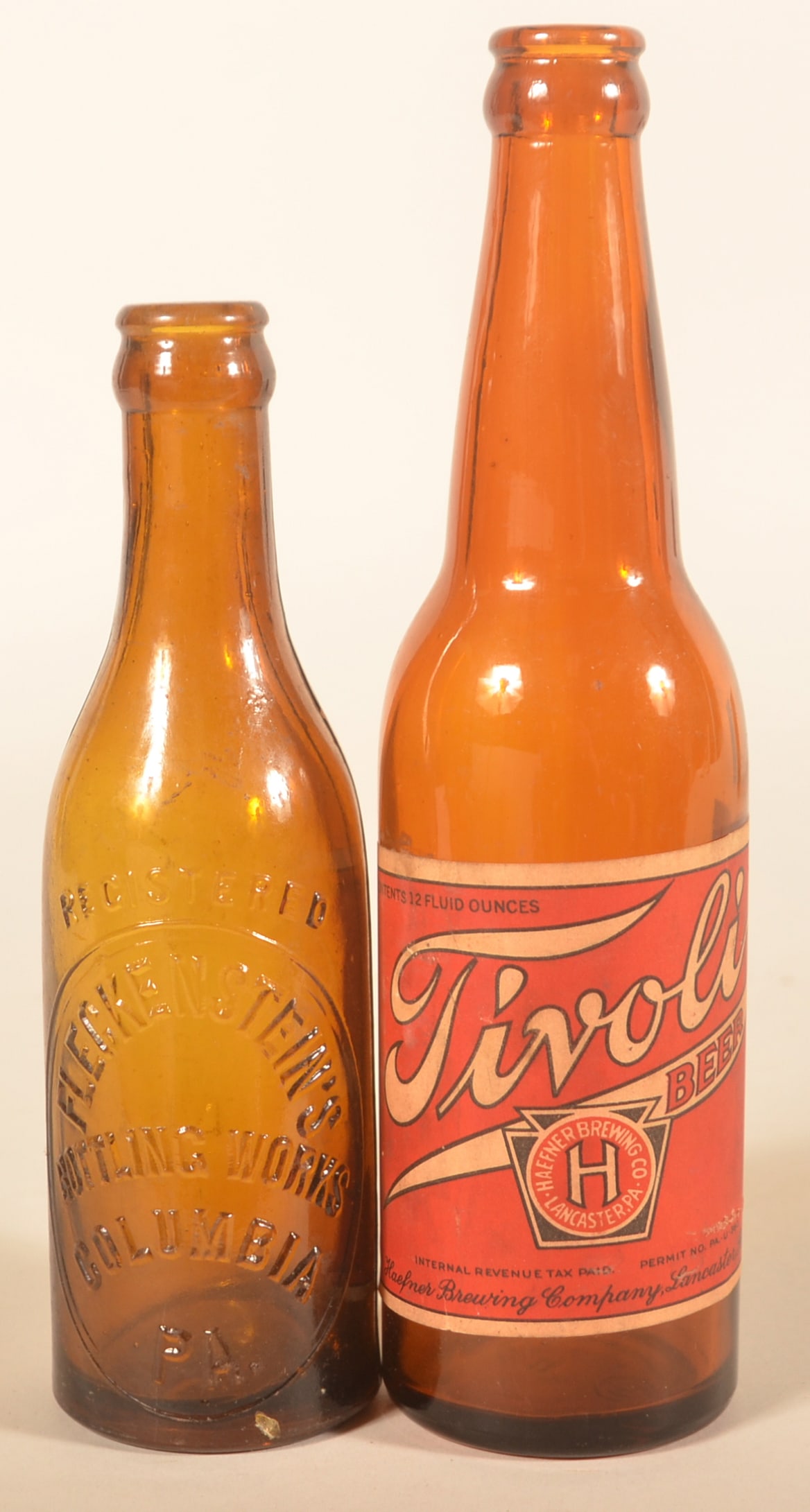 Amber Tivoli Beer & Fleckenstein's Bottles: Tivoli paper label bottle brewed by Haefner in Lancaster, Pa. Amber Fleckenstein's Bottling Works from Columbia, Pa. Two bottles. Tivoli bottle, 9 1/2"H