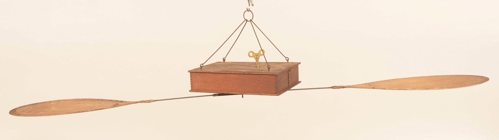 Early Key-Wind Mechanical Ceiling Fan: Oak dovetailed box with key wind mechanism that turns the two blades. Wire hangers clip together to hang. Wire hoop on side acts as the on/off switch. Original canvas blades. 1870-1880. Provenance: