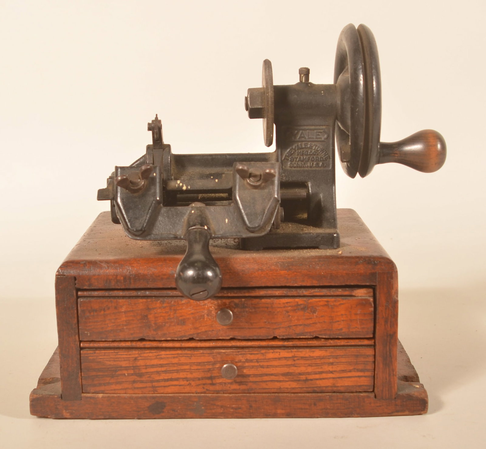 The Yale and Towne MFG Co. Mechanical Key Cutter: Early version of the key cutter. Oak, 2-drawer base with cast iron hand-turned machine that cuts the key. Provenance: The collection of Russell and Darlene Snyder. 11 1/2"H x 12"W x 9 1/2"D