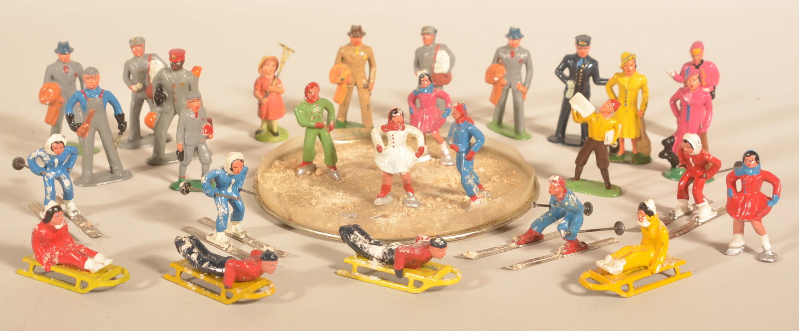 Collection Barclay 1950s Skaters & People: Small collection of figures including smaller skaters, skiers and sledders with larger town folk. Ice rink included. Tallest figure, 3"