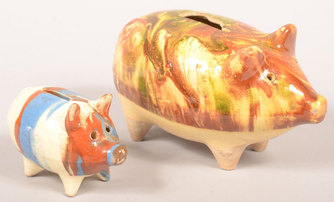 114. Two Earthenware Pottery Pig Form Still Banks.: 114. Two Earthenware Pottery Pig Form Still Banks. Multicolor slip designs, 2-3/4"h.and 4"h. Condition :Smaller one rough on ear, large with coin slot damage.