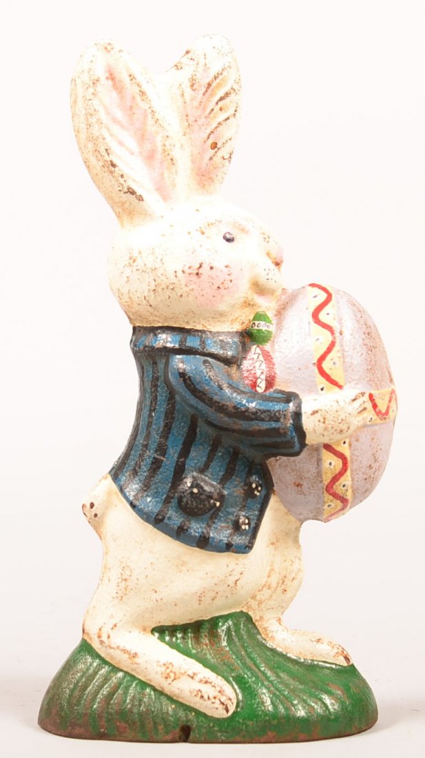 123. Painted Cast Iron Rabbit Doorstop. Standing rabbit: 123. Painted Cast Iron Rabbit Doorstop. Standing rabbit holding egg, Signed Pittsburg Foundry, 11"h. Condition: Good.