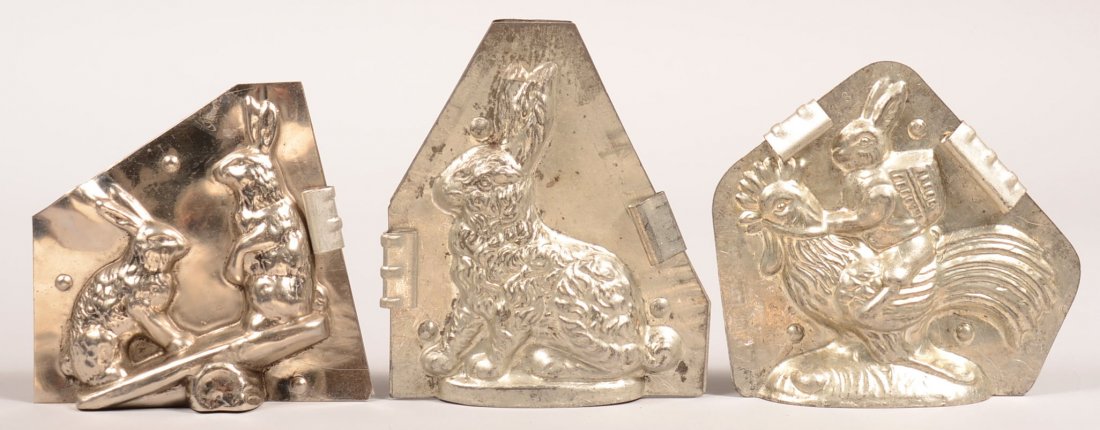 317. Three Rabbit Chocolate Molds. Rabbit riding: 317. Three Rabbit Chocolate Molds. Rabbit riding Rooster, Two rabbit on See-Saw,( attributed to LeTan), Seated rabbit signed Jaburg Brothers, 5-1/4"h.- 6-1/4"h. Condition: Good.