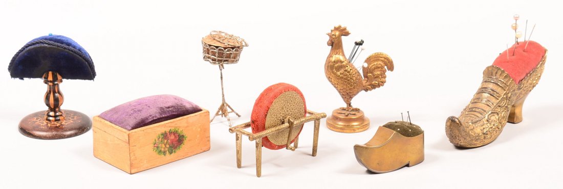 503. Lot of Seven Various Pin Cushions/Holders: 503. Lot of Seven Various Pin Cushions/Holders including a brass rooster and inlaid wood pedestal. Rooster measures 4" high. Condition: Good with use wear.