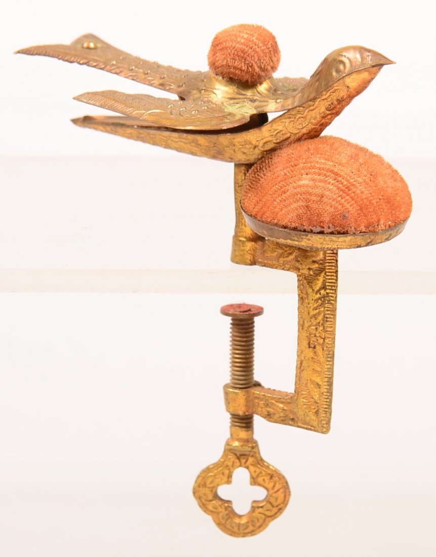 534. Victorian Brass Sewing Bird with "C" clamp and: 534. Victorian Brass Sewing Bird with "C" clamp and double pin cushions. 4-3/4" high. Condition: Good with wear.