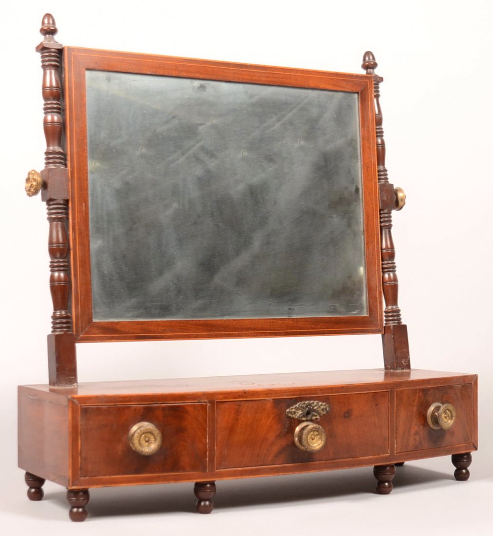 553. American Sheraton Mahogany Shaving Stand, Circa.: 553. American Sheraton Mahogany Shaving Stand, Circa. 1820-1830. Tilt mirror with turned supports having acorn finials, bow front with three dovetailed drawers and turned feet. 23"h x 22"w x 8-1/2"d. 