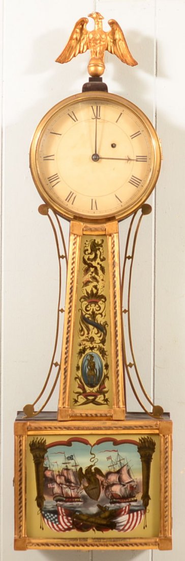 700. Unsigned Banjo Clock. Mahogany case, lower panel: 700. Unsigned Banjo Clock. Mahogany case, lower panel with fighting naval scène, gilt painted wood spread wing eagle finial, 34"h. Condition: Good with old repair on eagle.