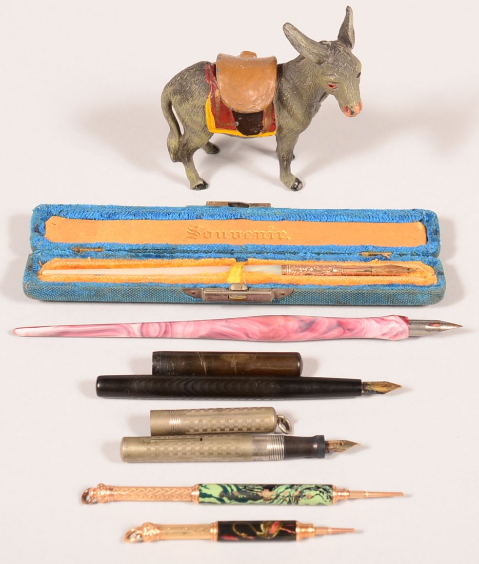 704. Grouping of Fountain Pens and Pencils. Including: 704. Grouping of Fountain Pens and Pencils. Including painted spelter painted Donkey form Inkwell, Mother of pearl pen with H.M. Smith & Co. New York Tip in a blue velvet souvenir hinge box, Paul E. W