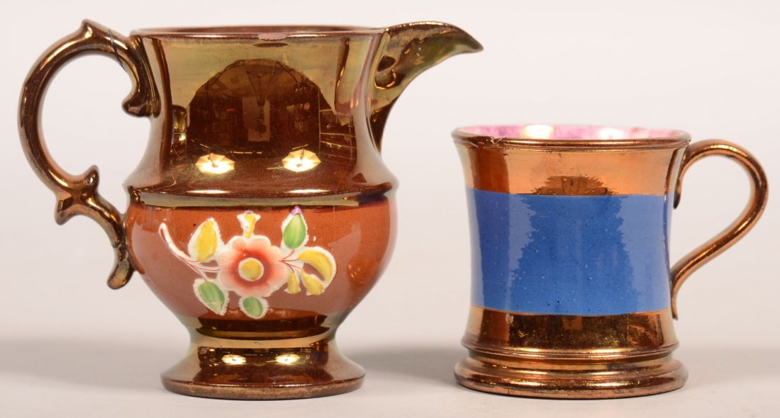 814. Two Pieces of Copper Lustre China; flared edge: 814. Two Pieces of Copper Lustre China; flared edge child's mug with blue band, 2-7/8"h. and a cream pitcher with embossed floral decoration on a rust colored band, 4"h. Condition: mug is good, pitche