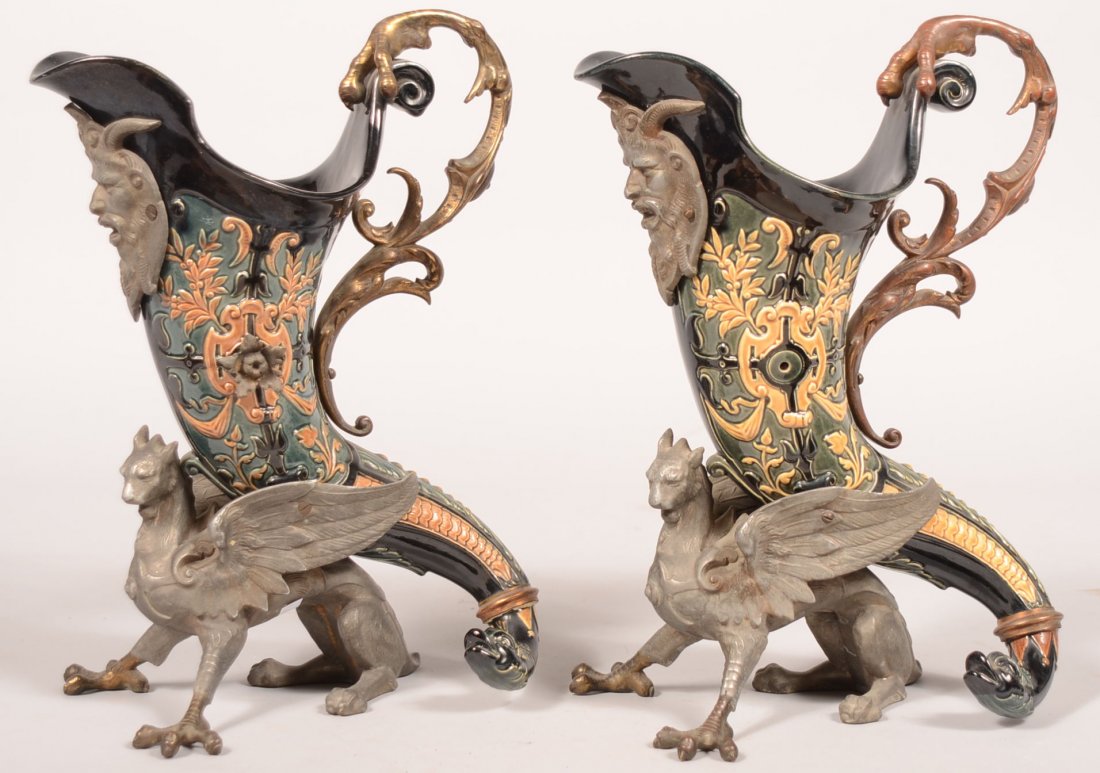 819. Pair of Majolica Pottery Ormolu Mounted Cornucopia: 819. Pair of Majolica Pottery Ormolu Mounted Cornucopia Ewers. Green, tan and black glazed majolica with floral, foliate and geometric designs and having dolphin head terminals. Pot metal mountings in