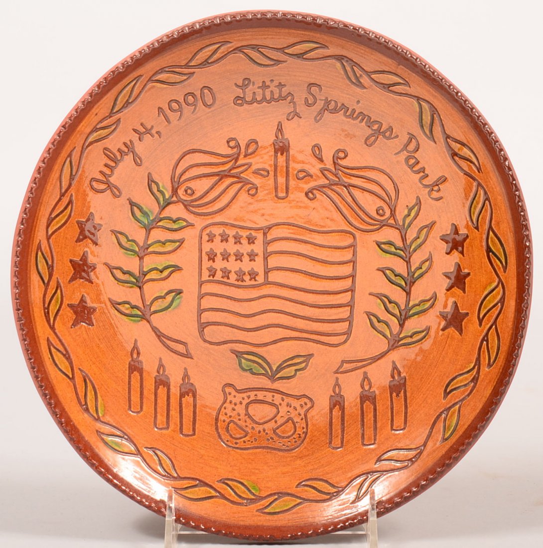 C. N. Foltz 1990 Lititz Spring Park Redware Plate.: C. N. Foltz 1990 Lititz Spring Park Redware Plate. Sgraffito decorated American flag, tulips, candles and pretzel, limited edition plate #54, 9-3/4"dia. Condition: Good.