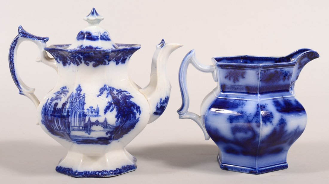 Two Pieces of Flow Blue Transfer Ironstone China.: Two Pieces of Flow Blue Transfer Ironstone China. "Gothic" pattern teapot, 9"h. and "Chapoo" pattern milk pitcher, 6-1/2"h. Condition: Teapot has a married lid with repairs, milk pitcher has minor gla