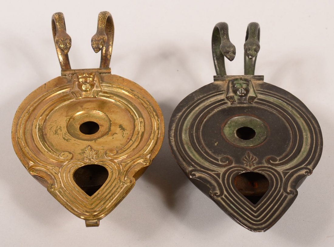 Two Brass Repeating Igniter Lighting Devices. England: Two Brass Repeating Igniter Lighting Devices. England circa. 1867, in the form of classical oil lamp, hinged cover with Egyptian figure head in relief, conceals a turntable advancing by mechanically b