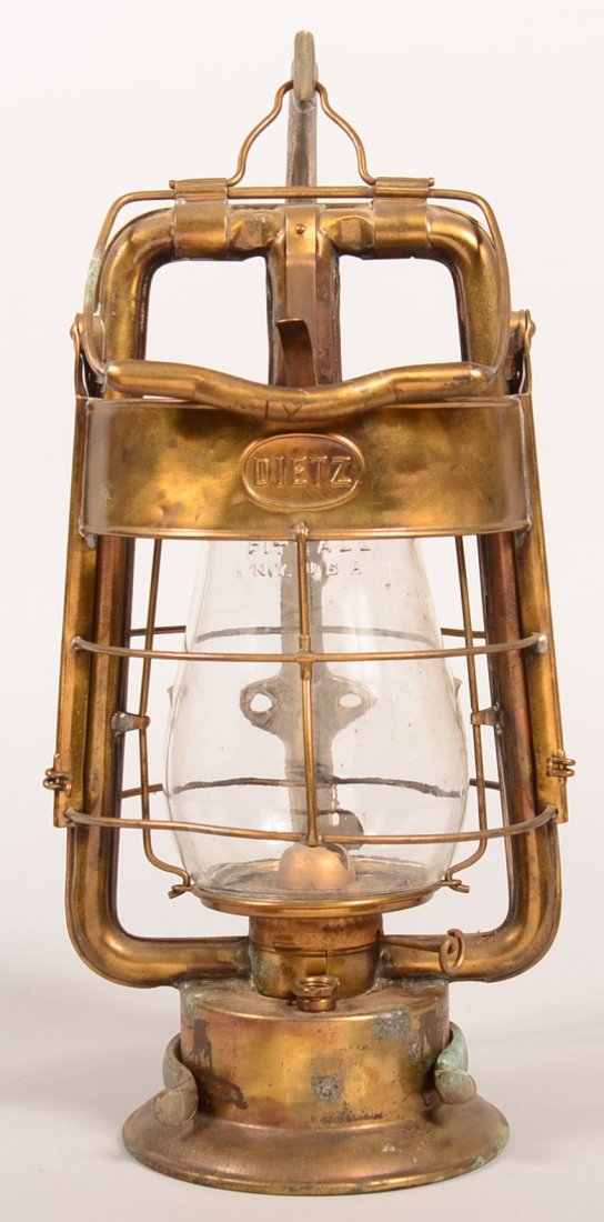 Dietz Brass Fireman's Lantern with wall hanging: Dietz Brass Fireman's Lantern with wall hanging bracket. Dietz King Fire Dept. Tubular frame with bail swing handle, hinged wire guard, patented date of aug.27 07, colorless glass globe, 16-1/2"h. Con