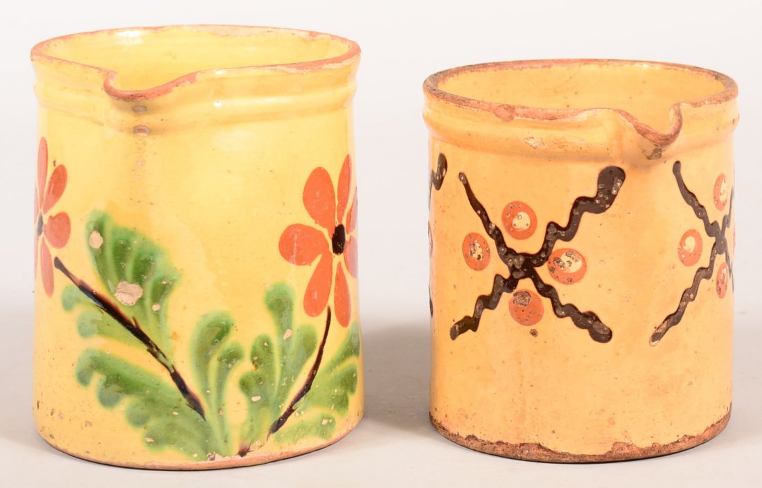 Two French Earthenware Milk Pitchers. Floral slip and: Two French Earthenware Milk Pitchers. Floral slip and geometric decorations, circa. 1910, 6-1/2" and 5-3/4"h. Condition: Good with chip and glaze loss.