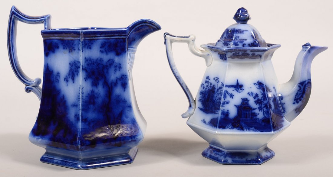 Two Pieces of Flow Blue Transfer Ironstone China;: Two Pieces of Flow Blue Transfer Ironstone China; "Chusan" pattern teapot, 9"h. and "Shanghai" pattern water pitcher, 9-1/4"h. Condition: Teapot has spout and lid repairs, pitcher has 2" vertical crac