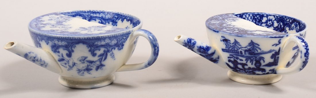 Two Flow Blue Transfer Decorated China Invalid Feeders.: Two Flow Blue Transfer Decorated China Invalid Feeders. Oriental view and floral decorated, 2-1/2" and 2-3/4" high. Condition: Floral design has a small spout chip, Oriental transfer is very good, no