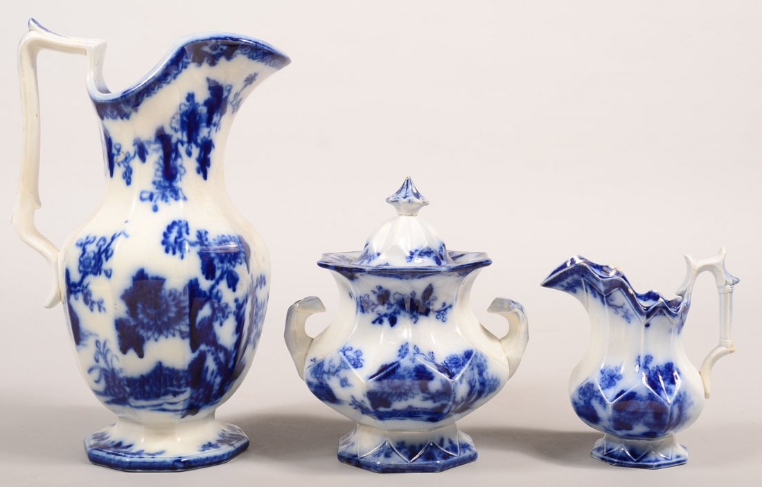 Three Pieces of Flow Blue Transfer Ironstone "Indian": Three Pieces of Flow Blue Transfer Ironstone "Indian" Pattern China. Paneled water pitcher, 12-1/2"h., covered sugar bowl, 7-3/4"h. and a cream pitcher, 6"h. Condition: Water pitcher has a repaired ha