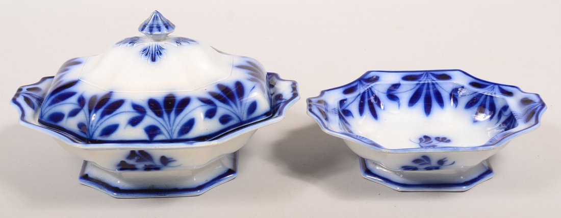 Two Flow Blue Brush Stroke "Leaf and Swag" Pattern: Two Flow Blue Brush Stroke "Leaf and Swag" Pattern Ironstone China Vegetable Bowls. One covered 7-1/2"h. x 12-1/2"w. and open vegetable bowl 10-1/4"w. Condition: Larger has two small chips, smaller ha