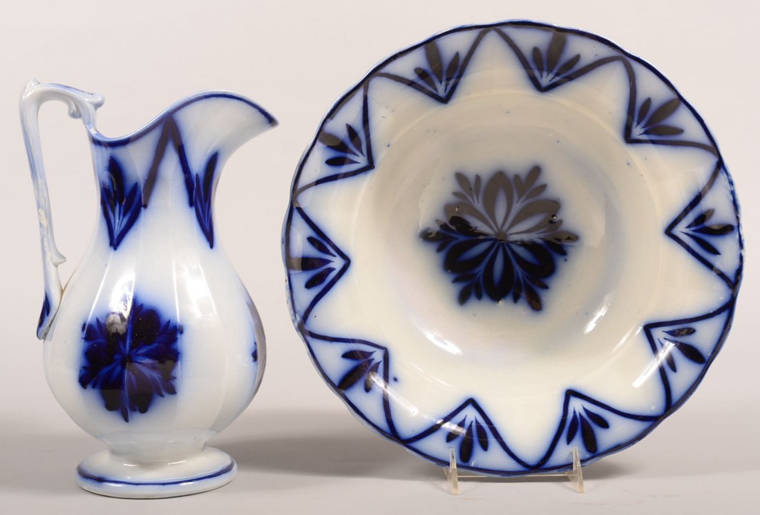 Flow Blue Brush Stroke "Floral and Sprig" Pattern: Flow Blue Brush Stroke "Floral and Sprig" Pattern Ironstone China Wash Bowl and Pitcher. Wash bowl, 13-3/4"diam., pitcher, 12-1/4"h. Condition: Pitcher is good, wash bowl has a 2" hairline on edge.