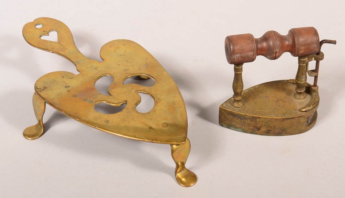 720. Brass Heart Shape Trivet and Sad Iron. Trivet with: 720. Brass Heart Shape Trivet and Sad Iron. Trivet with pinwheel and heart cut out design and flatten feet, iron with tear drop flat base with heating slug and wooden turned handle, trivet 2"h. x 10-1