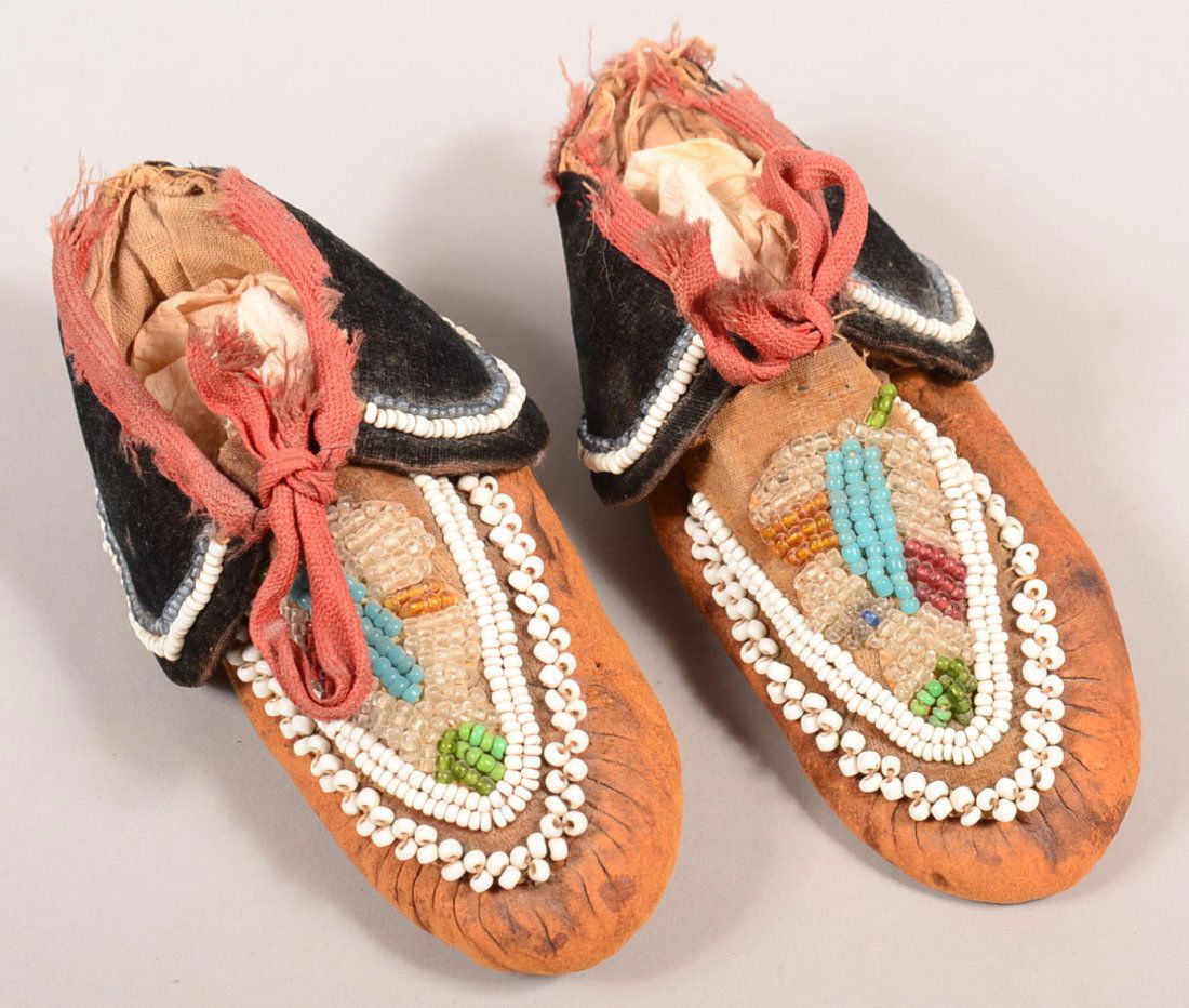A pair of old Caughnawaga Mohawk Indian moccasins with: A pair of old Caughnawaga Mohawk Indian moccasins with floral beaded vamp, beaded velvet cuffs - child sized. Fair