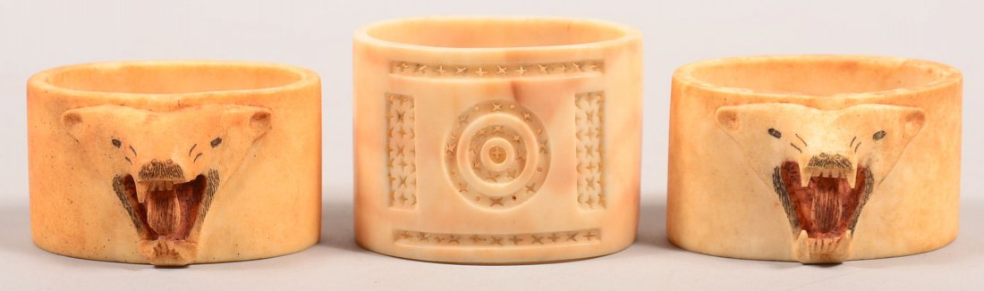 3 antique Eskimo carved walrus ivory napkin rings - a: 3 antique Eskimo carved walrus ivory napkin rings - a pair with polar bear headsin high relief (minor damage to one head)