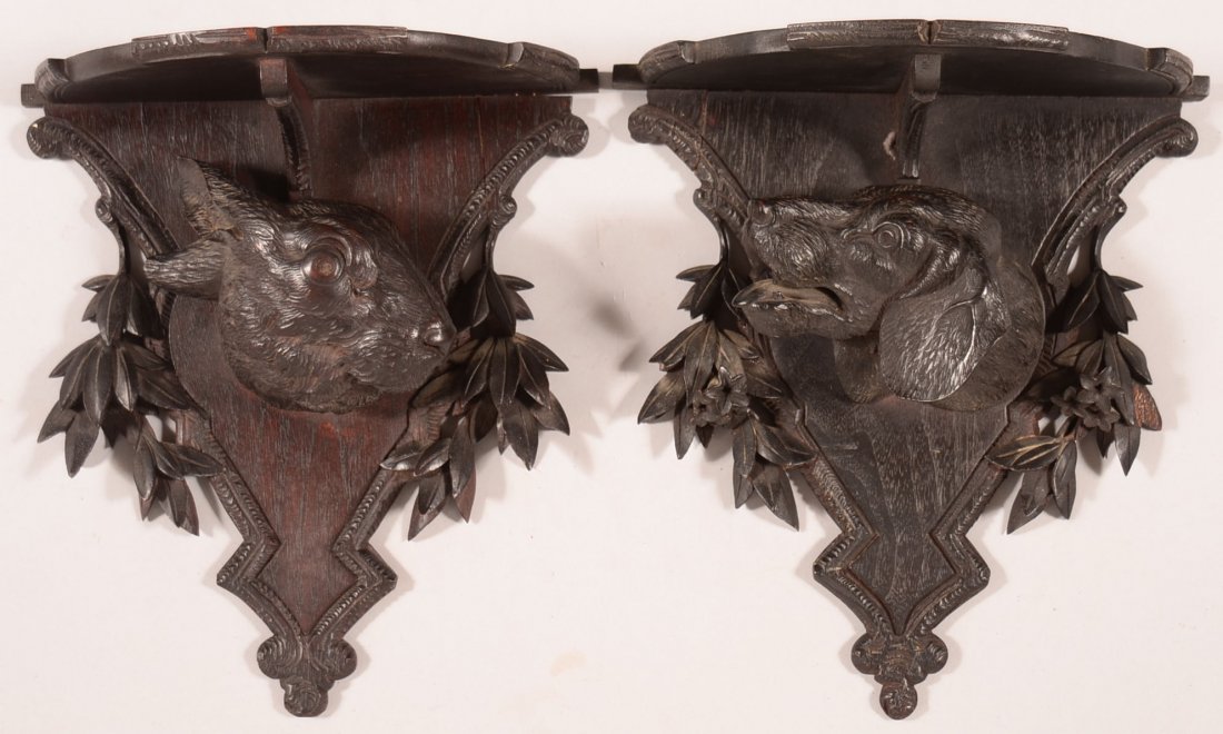 Pair of American Victorian Walnut Wall shelves with: Pair of American Victorian Walnut Wall shelves with Hound and Rabbit Head Motifs. Circa. 1880-1890. Half circular shelf with stepped molding and shaped wall supports with floral and foliate carvings. 