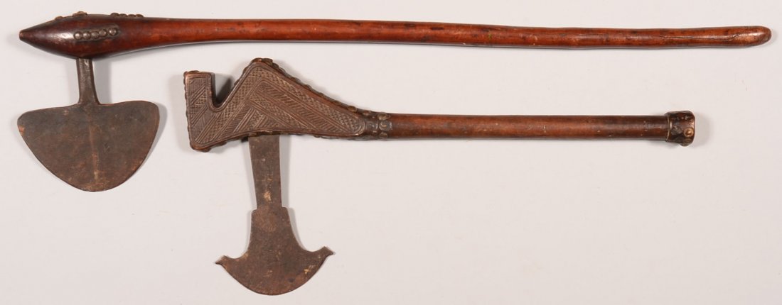 Lot of (2) antique tribal battle axes with hand forged: Lot of (2) antique tribal battle axes with hand forged iron blades and tack decorated wood hafts. One is an older example with a finely carved haft. Condition: good.