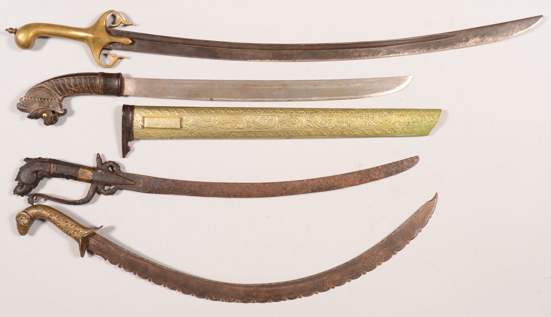 Lot of (4) exotic swords: (2) early Indo Persian; (2): Lot of (4) exotic swords: (2) early Indo Persian; (2) Indonesian with carved wood and buffalo handles-one with decorated stamped metal on scabbard. 22-1/2" to 30" overall. Condition: fair to very good