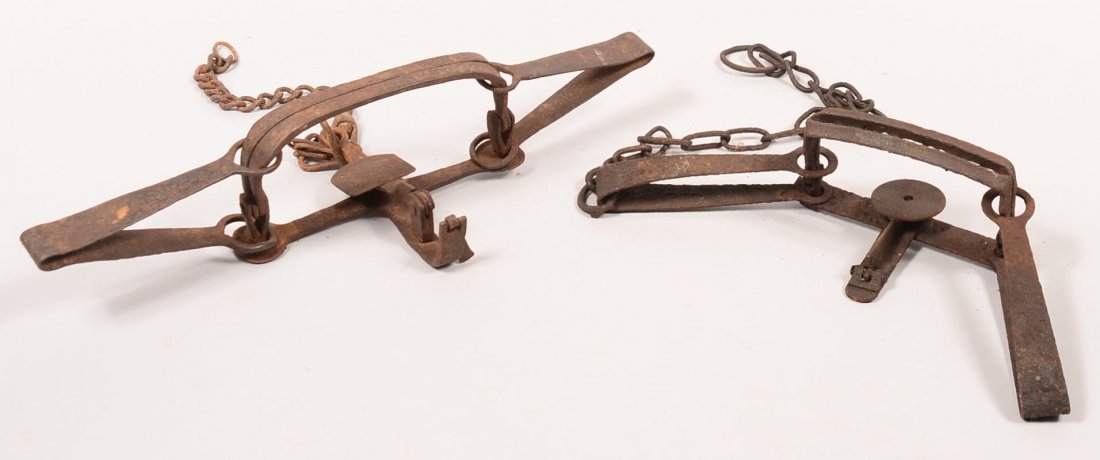 Lot of (2) antique double longspring hand forged leg: Lot of (2) antique double longspring hand forged leg hold steel traps. The first is 20" o/a having 6-1/4" wide jaws with (6) teeth and a 26" chain with a swivel and large anchoring ring. The second is